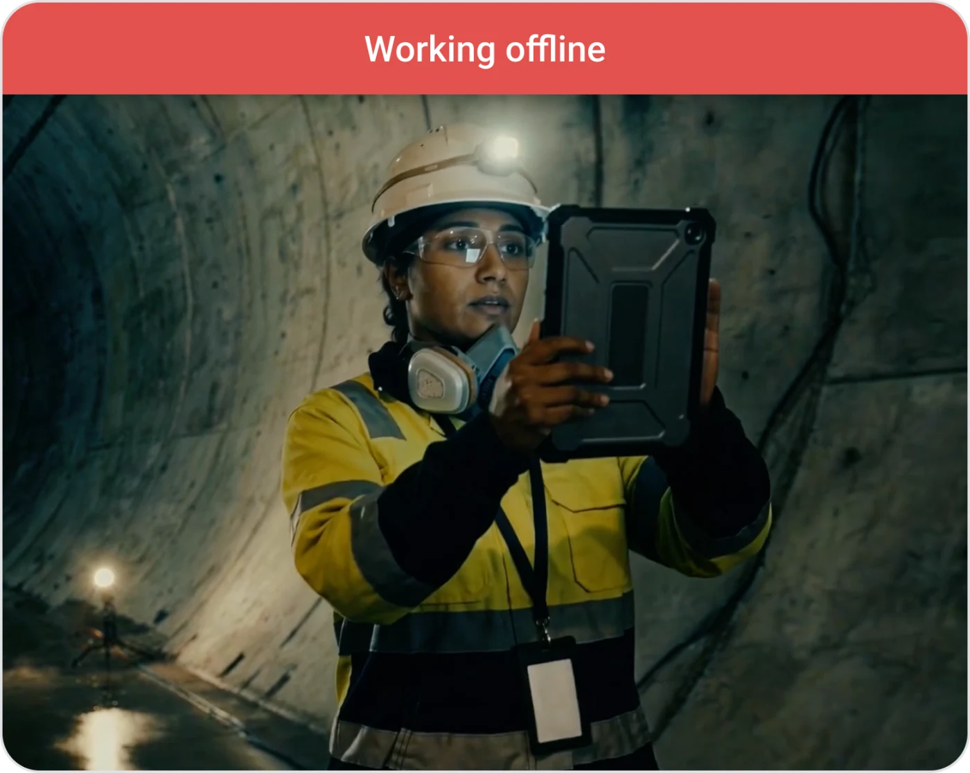 A worker using a tablet in a tunnel with a Working offline banner